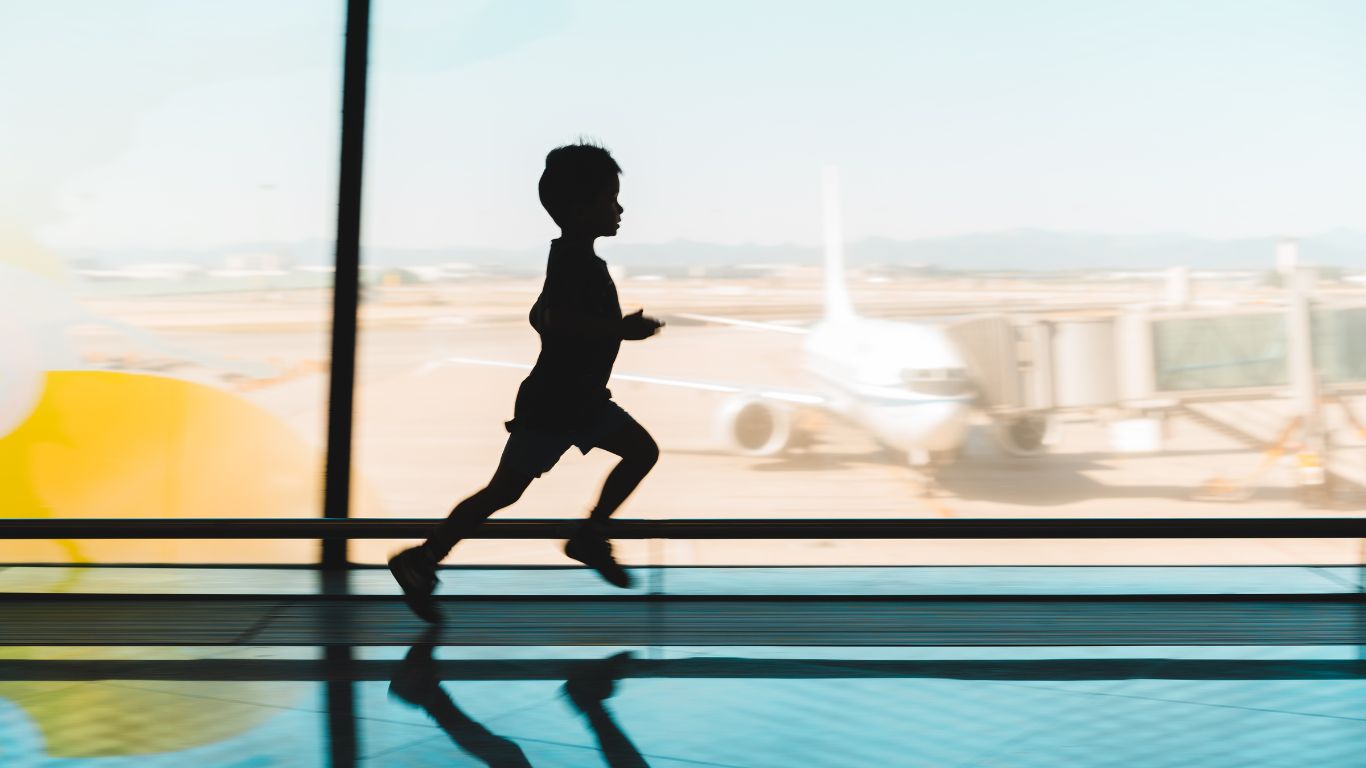 a woman holding a small child in front of a wall with the words "Everyone is welcome"